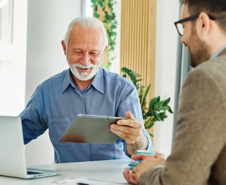 Couple de seniors assis sur canapé bleu consultant un conseiller financier
